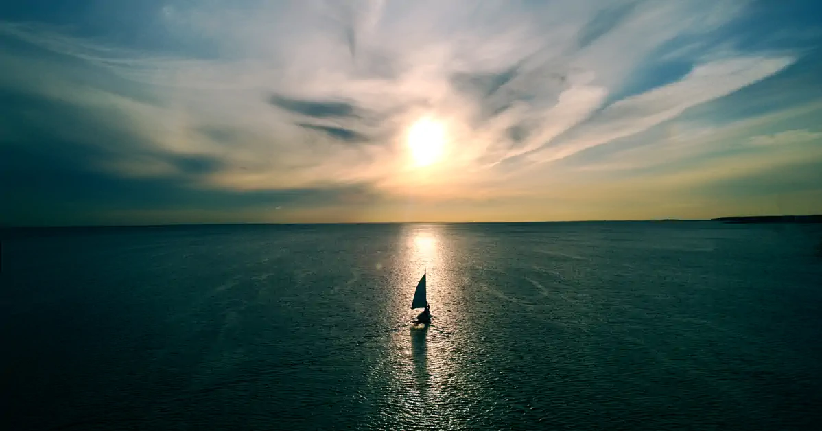 Yacht sailing into sunset